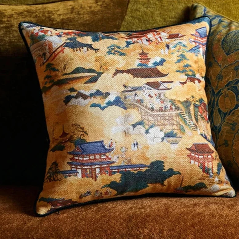 Housse de Coussin Zen 50x50 décoratif carré avec des motifs asiatiques traditionnels, comprenant des pagodes rouges et des montagnes stylisées sur un fond doré à texture brodée. - sur canapé