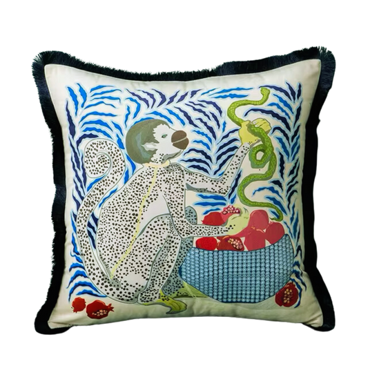 housse de coussin blanc avec dessin illustrant un singe blanc à pois noirs tenant un serpent vert à côté d'un panier rempli de grenades rouges, sur fond de motifs abstraits en bleu - de face