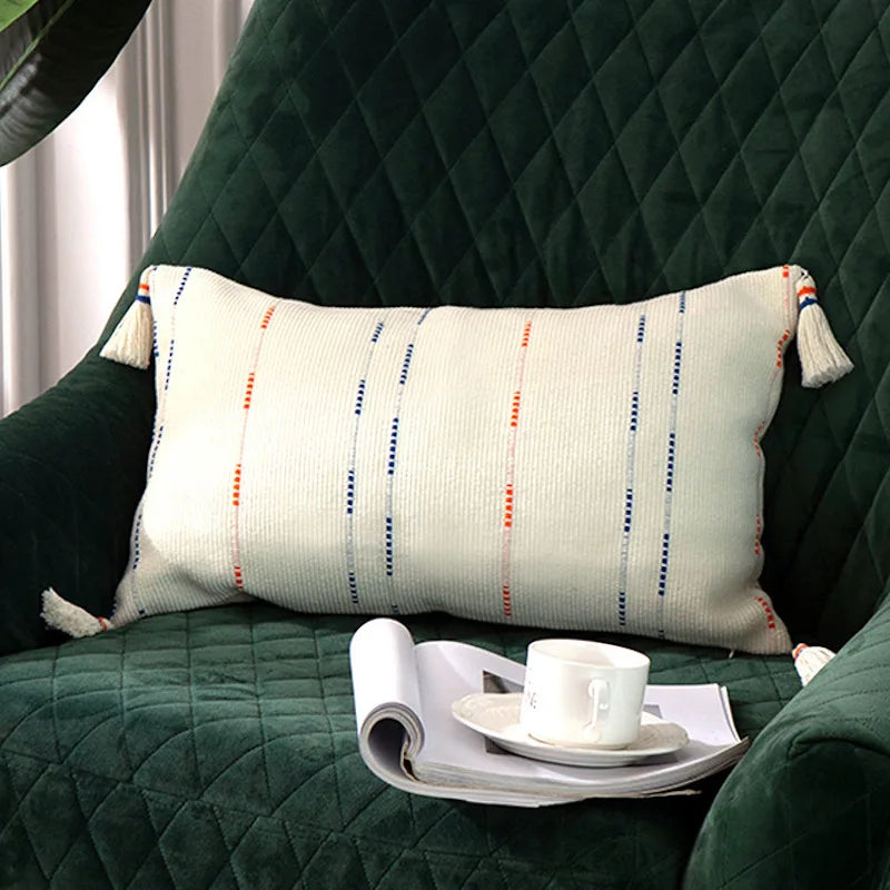 Housse de Coussin Blanc au Crochet avec lignes verticales bleues et orange et bandes horizontales en bas - version rectangle sur fauteuil vert irlandais