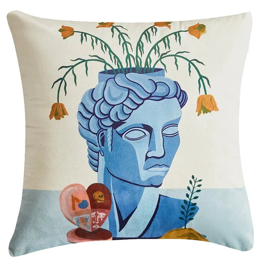 housse de coussin a feuilles bleu vert blanc Illustration surréaliste d'un buste bleu de style gréco-romain servant de pot de fleurs, avec des fleurs orange tombantes, accompagnée d'objets décoratifs abstraits, sur un fond minimaliste beige et bleu clair - de face