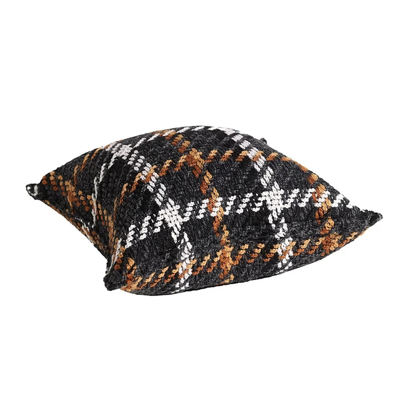 Housse Coussin Carreaux Noir et Blanc texturé avec un motif tartan en noir, blanc, marron, et orange, sur fond blanc - de 3/4 couché