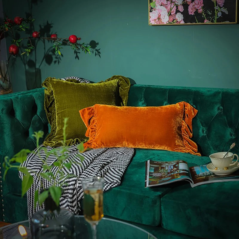 Housse de Coussin Velours Vert olive avec des bordures en volants, capturé dans un style photoréaliste sur un fond blanc, mettant en valeur la texture douce et brillante du velours - sur canapé vert emeraude 