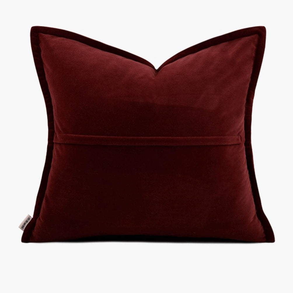 Housse de Coussin Rouge Tendances en velours avec un motif texturé et abstrait en relief de couleur dorée représentant des éléments naturels. La lumière douce met en valeur les détails sans créer de fortes ombres - de dos