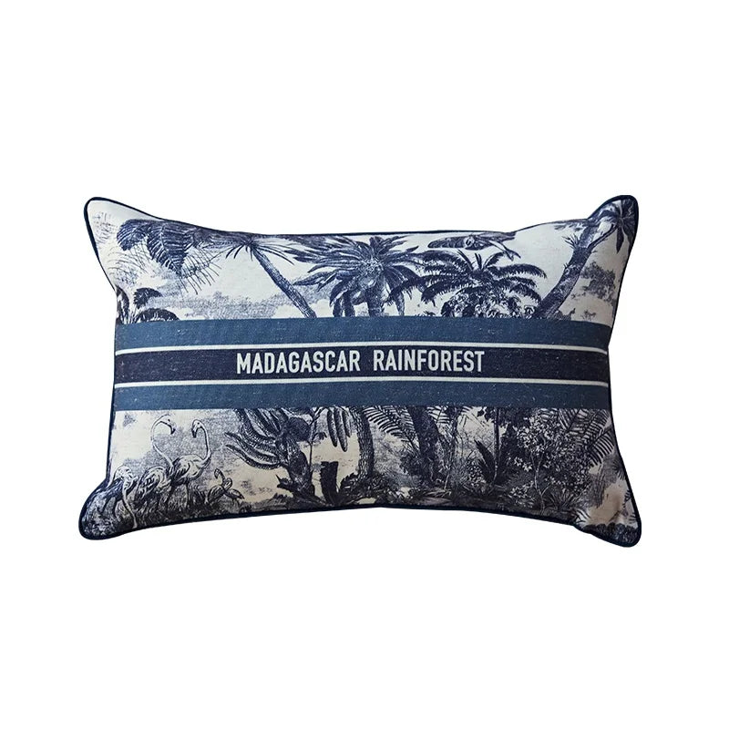 Housse de Coussin 45x45 avec Lettre représentant la forêt tropicale de Madagascar avec des palmiers, des flamants roses et un grand papillon. Le texte "MADAGASCAR RAINFOREST" est centré, encadré par deux lignes horizontales - version rectangle