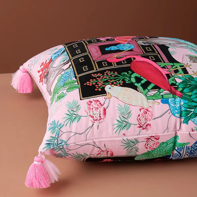 Housse de Coussin Rose Fushia avec une illustration détaillée incluant un flamant rose, un singe, un léopard, des plantes et des éléments décoratifs bleus et blancs - couché 