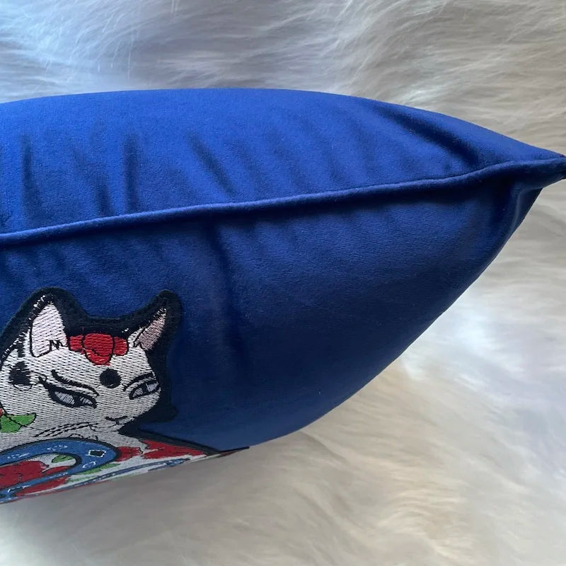 housse de coussin chat vintage en velours bleu profond avec une broderie artistique représentant un chat stylisé entouré de fleurs rouges et d'un serpent bleu, inspiré par l'art japonais traditionnel - zoom sur passepoil