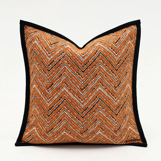 Housse de Coussin Orange 50x50 moderne avec une housse à motif zigzag orange, noir et blanc, et une bordure noire sur un fond uni clair - de face