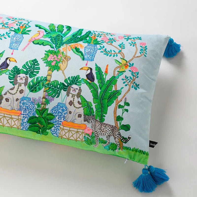 housse de coussin rectangulaire en velours avec motifs tropicaux avec des perroquets, des toucans, des léopards et des plantes luxuriantes, orné de pompons bleus - zoom sur coté droit