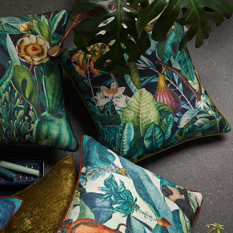 housse de coussin jungle 50x50 colorée et détaillée d'un coussin décoratif avec des feuilles tropicales vertes, des fleurs exotiques et un singe, bordé de rouge - vue en plongée