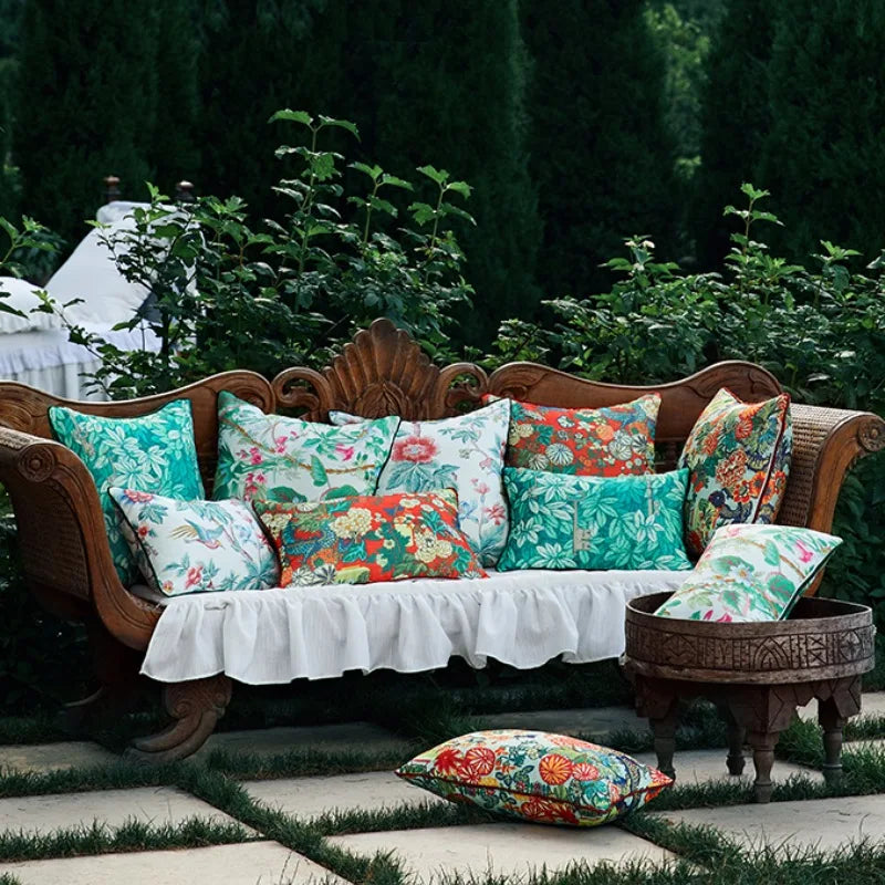 Housse de Coussin 45x45 Feuille Vert avec un motif tropical, composé de grandes feuilles vertes et turquoise entrelacées avec des clés dorées vintage. Design élégant et moderne sur fond blanc - deuxime photo sur banquette dans jardin