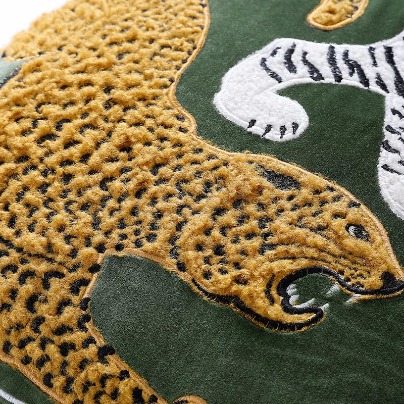 Housse de Coussin Jaune et Vert décoratif avec un tigre blanc et un léopard doré en broderie sur fond vert, avec des glands noirs aux coins - zoom sur le lepoard