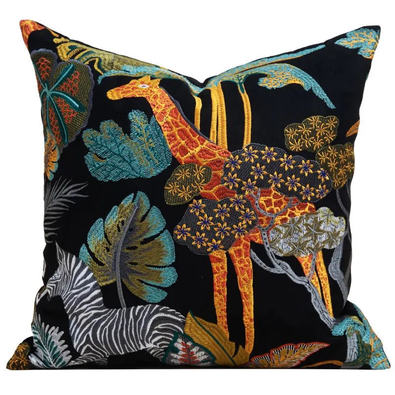 Housse de Coussin en Velours Jungle brodé avec une girafe orange et jaune, un zèbre noir et blanc, entourés de feuilles tropicales colorées sur un fond noir, style exotique et élégant - de face