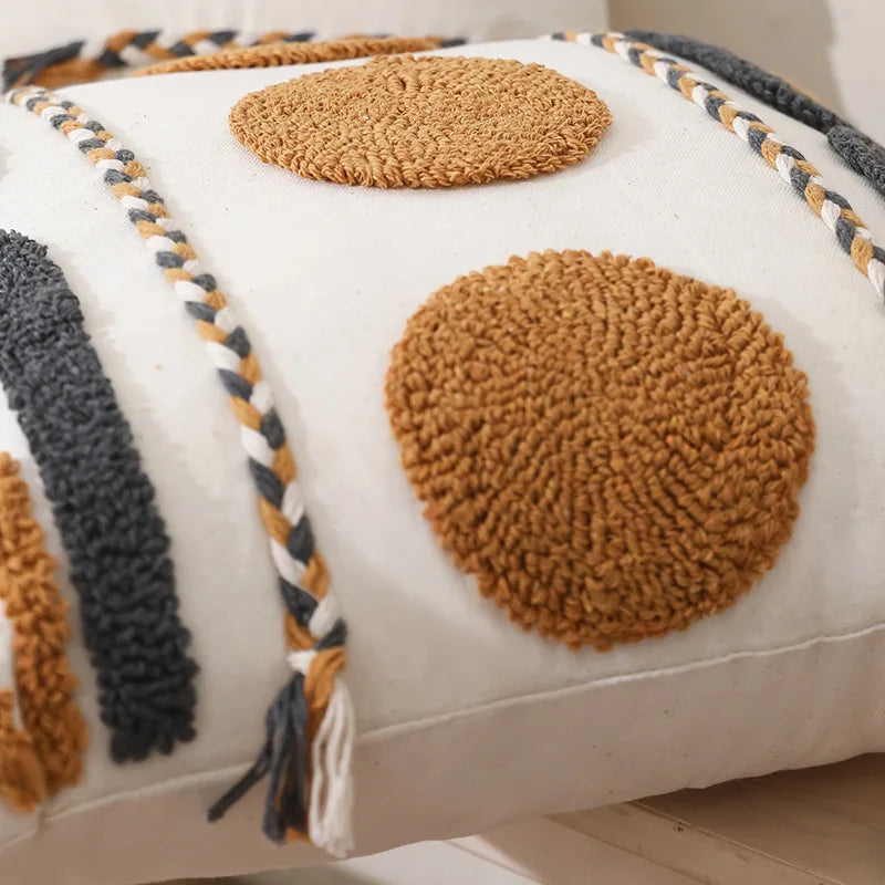 Housse de Coussin Style Boheme Terracotta décoratif au style bohème minimaliste, avec broderies en relief de formes géométriques jaunes moutarde et grises anthracite, sur fond blanc texturé. Bordures tressées artisanales - zoom sur détails