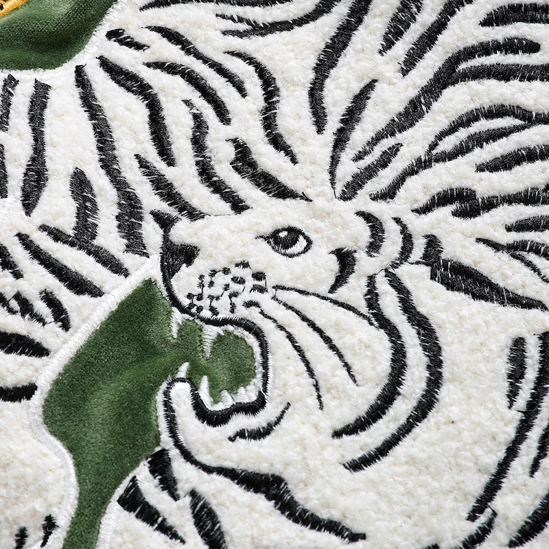 Housse de Coussin Jaune et Vert décoratif avec un tigre blanc et un léopard doré en broderie sur fond vert, avec des glands noirs aux coins - Zoom sur le tigre