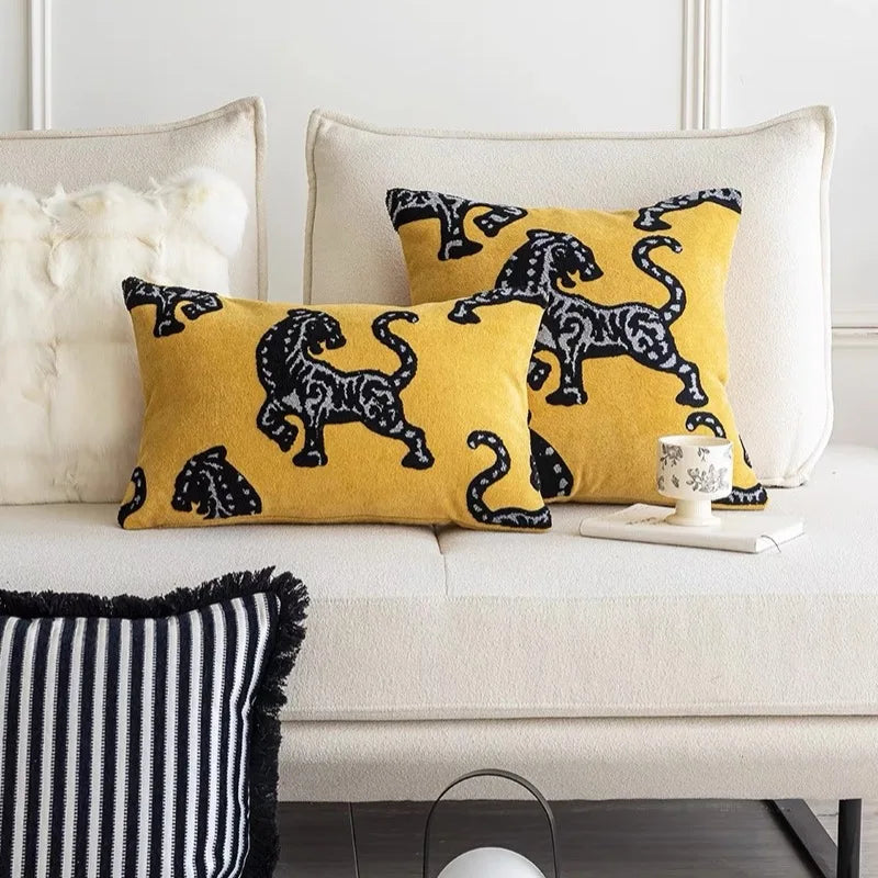 Housse de Coussin Jaune Moutarde et Gris moderne décoré de motifs de panthères noires abstraites avec des détails gris, inspiré du design textile contemporain - avec version rectangle sur canapé blanc