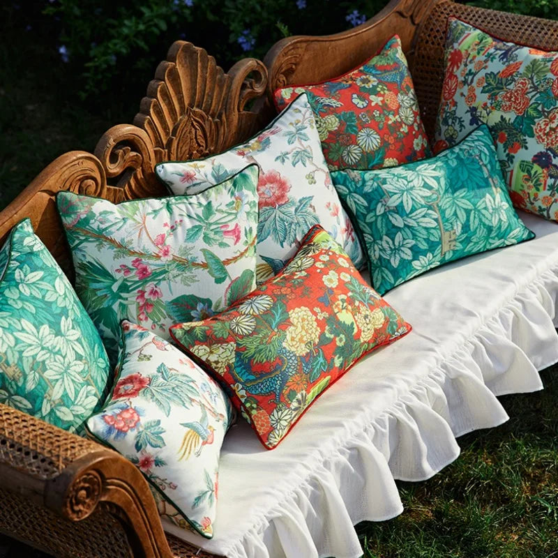 Housse de Coussin 45x45 Feuille Vert avec un motif tropical, composé de grandes feuilles vertes et turquoise entrelacées avec des clés dorées vintage. Design élégant et moderne sur fond blanc - prise plongée sur banquette