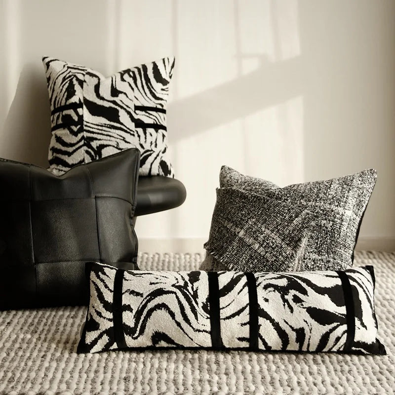 housse de coussin zebre 50x50 moderne avec un motif zèbre noir et blanc, comportant deux bandes horizontales noires au centre, sur un fond blanc - mis en scène avec d'autres coussins