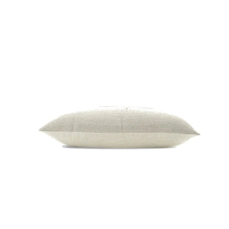 housse de coussin couleur gris claire en lin en tissu gris et beige avec une broderie centrale représentant un oiseau stylisé aux ailes déployées, sur fond blanc, style minimaliste et naturel - couché