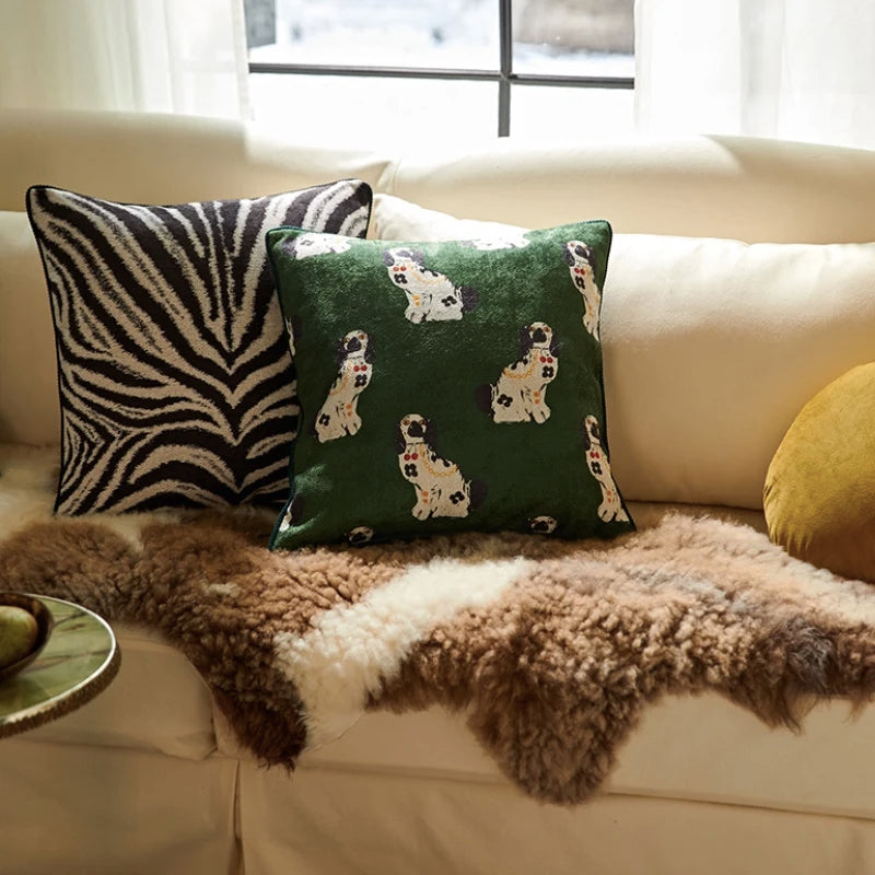 housse de coussin 50x50 noir et blanc avec un motif de zèbre noir et blanc symétrique, présenté sur un fond uni et lumineux, style minimaliste et contemporain - sur canapé blanc avec coussin vert et jaune