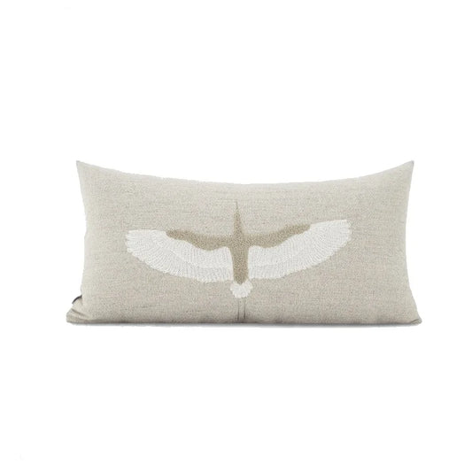 housse de coussin couleur gris claire en lin en tissu gris et beige avec une broderie centrale représentant un oiseau stylisé aux ailes déployées, sur fond blanc, style minimaliste et naturel - de face